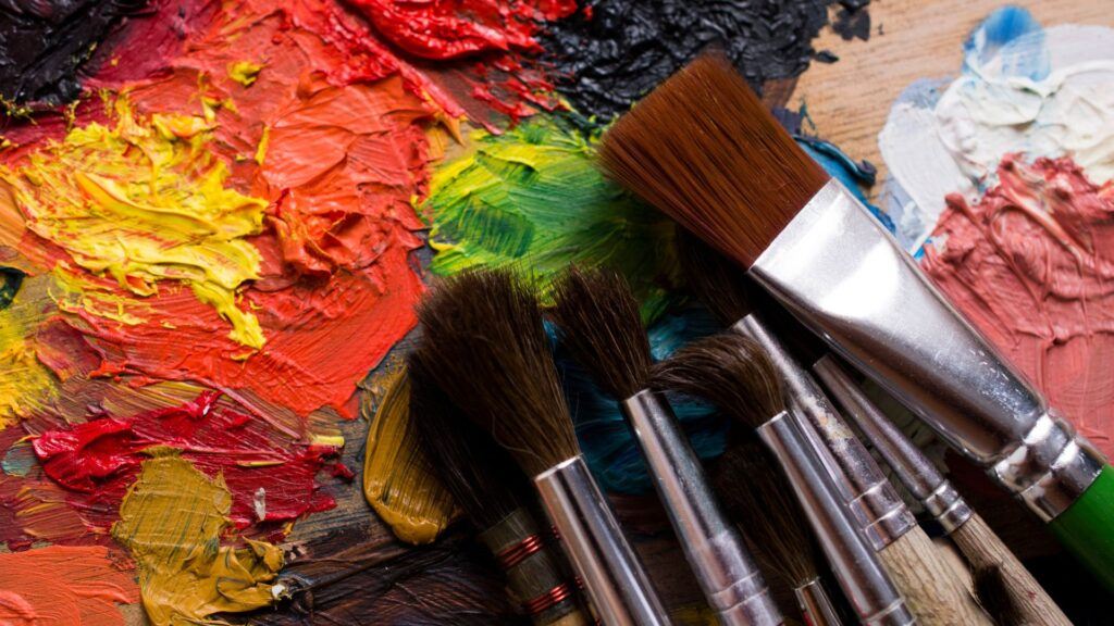 artist brushes and different colors of oil paint