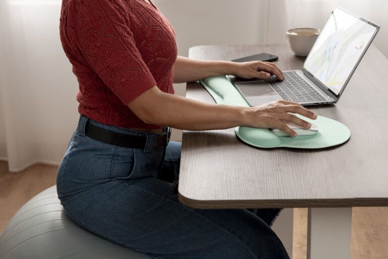 person working at computer while using a wrist rest